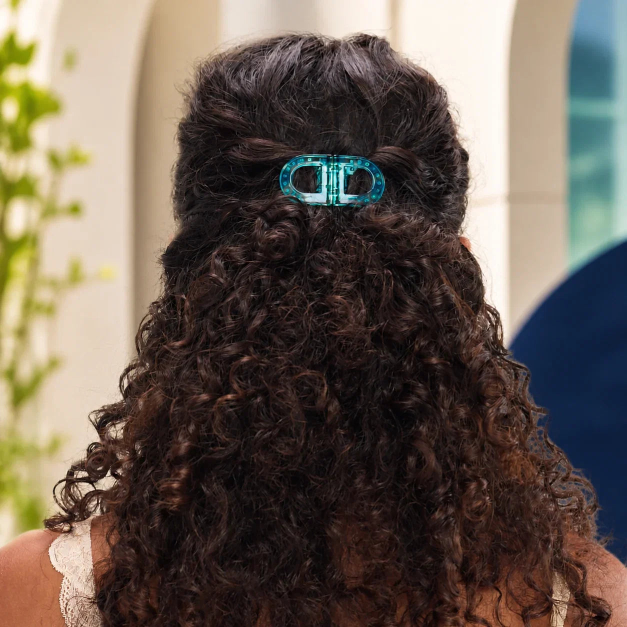 Turquoise MagniClip in een half opgestoken krullend kapsel