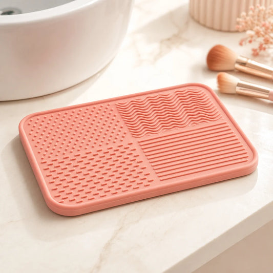 PIMOVO coral makeup brush cleaning mat beside a bright vanity sink
